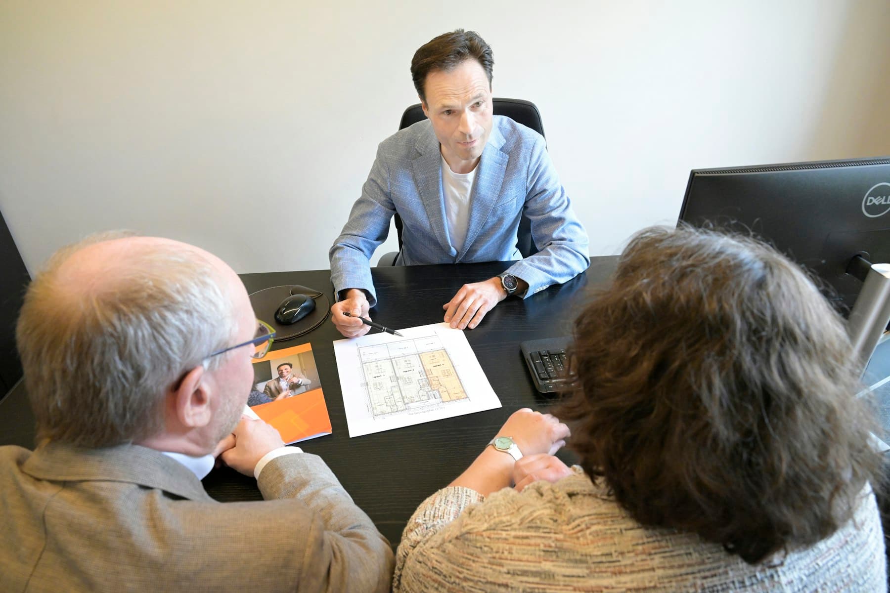 An attorney reviewing documents with a client across a desk.