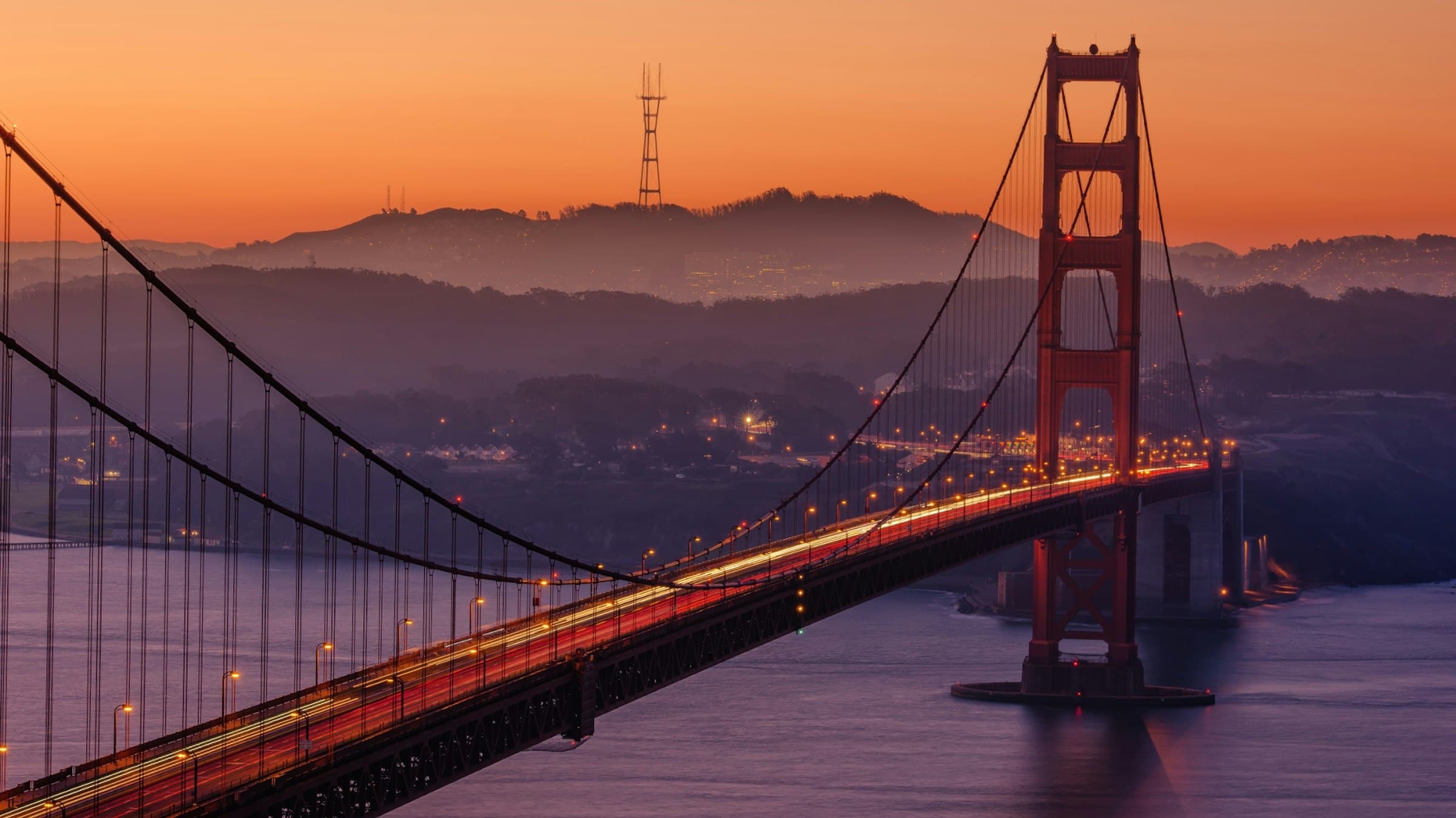 The Golden Gate Bridge at dusk with the Marin hills behind it.